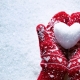 Christmas mittens holding snow heart
